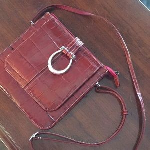Brighton red crossbody purse with built in wallet and heavy horse shoe close.